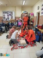Dziewczynki ćwiczące resuscytację na fantomach razem z ratownikami