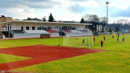 Zdjęcie przedstawia budynek Stadionu Miejskiego na tle murawy