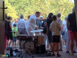 muzycy z zespołu Topside na scenie muszli koncertowej w towarzystwie publiczności