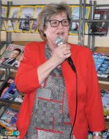 Jubileuszowe spotkanie dyskusyjnego klubu książki - kobieta z mikrofonem w ręku