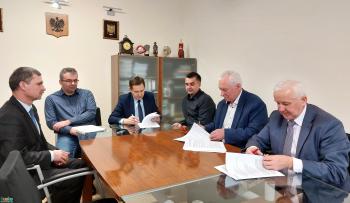 Zdjęcie przedstawia podpisanie umowy na budowę hali sportowej w Szańcu
