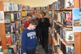 Dzieci oglądają książki na regałach bibliotecznych