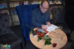 Grzegorz Rak podpisuje egzemplarz książki