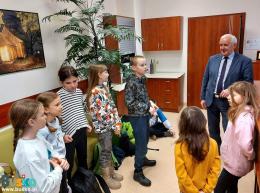 dzieci zwiedzają pomieszczenia w UMiG w Busku-Zdroju w towarzystwie burmistrza Waldemara Sikory